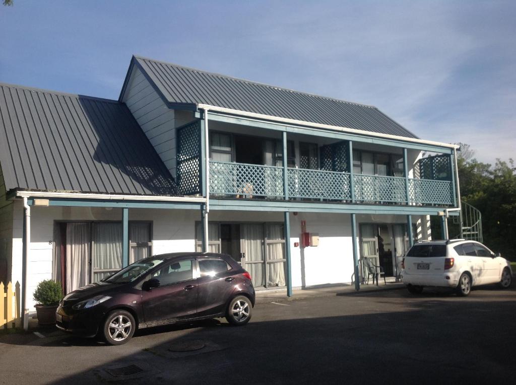 a car parked in front of a building with a balcony at Breeze Motels in Greymouth