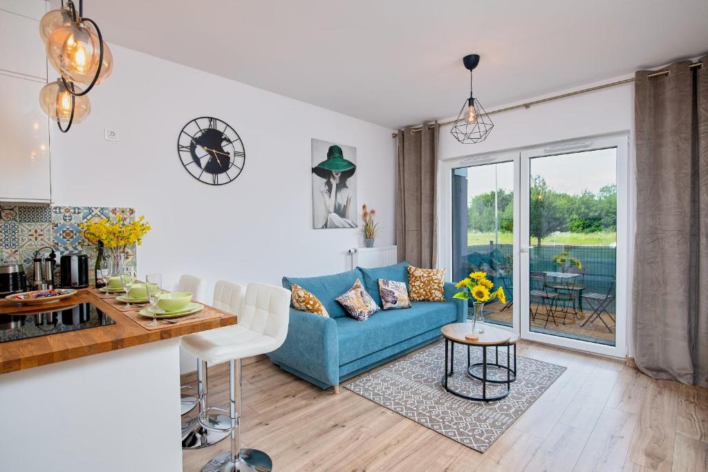a living room with a blue couch and a table at Poznań Grunwald - Parking & Terrace - by Rentujemy in Poznań