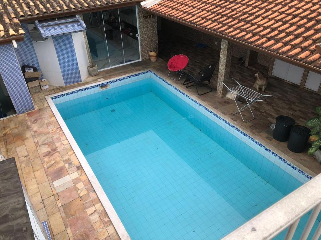 una vista aérea de una piscina con una silla roja en Casa descanso Caraguá 1, en Caraguatatuba