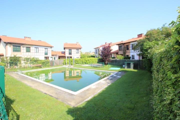 a small swimming pool in a yard with houses at Mies de Prado in Comillas