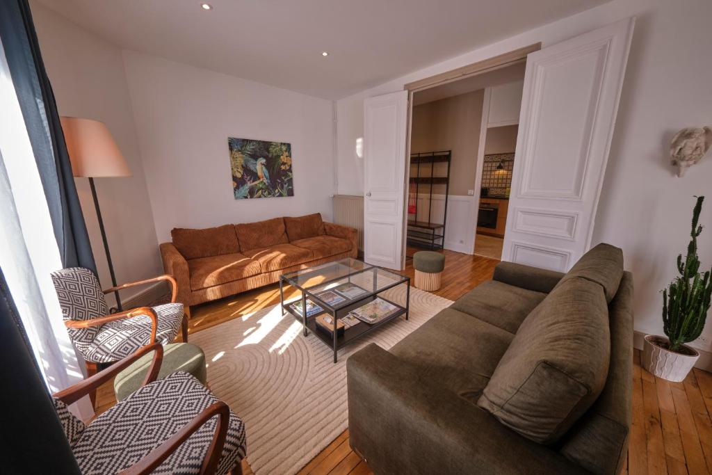 un salon avec un canapé et une table dans l'établissement Le Voltis, à Épernay