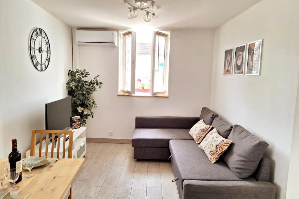 una sala de estar con un sofá y una mesa en Séjour magique proche aéroport CDG Astérix Disney et Paris Maison toutes commodités, terrasse, WIFI, CLIM, lave vaisselle, en Saint-Mard