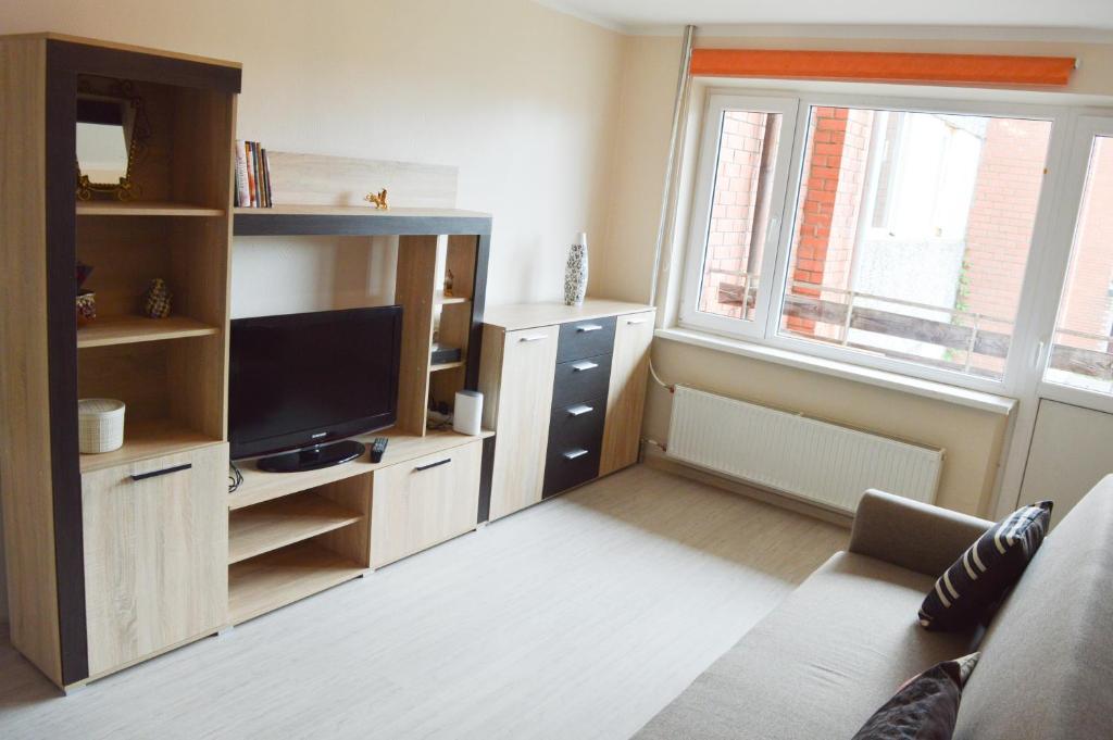 a living room with a couch and a tv and a window at Cherry Apartment in Madliena
