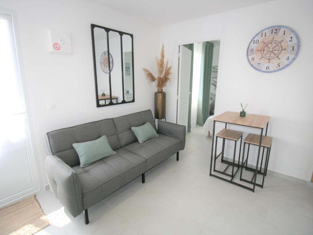 un salon avec un canapé et une table dans l'établissement Maisonnette rénovée 2/3 pers, déco soignée, 750m plage, jardin commun, emplacement voiture - FR-1-22-348, à La Tranche-sur-Mer