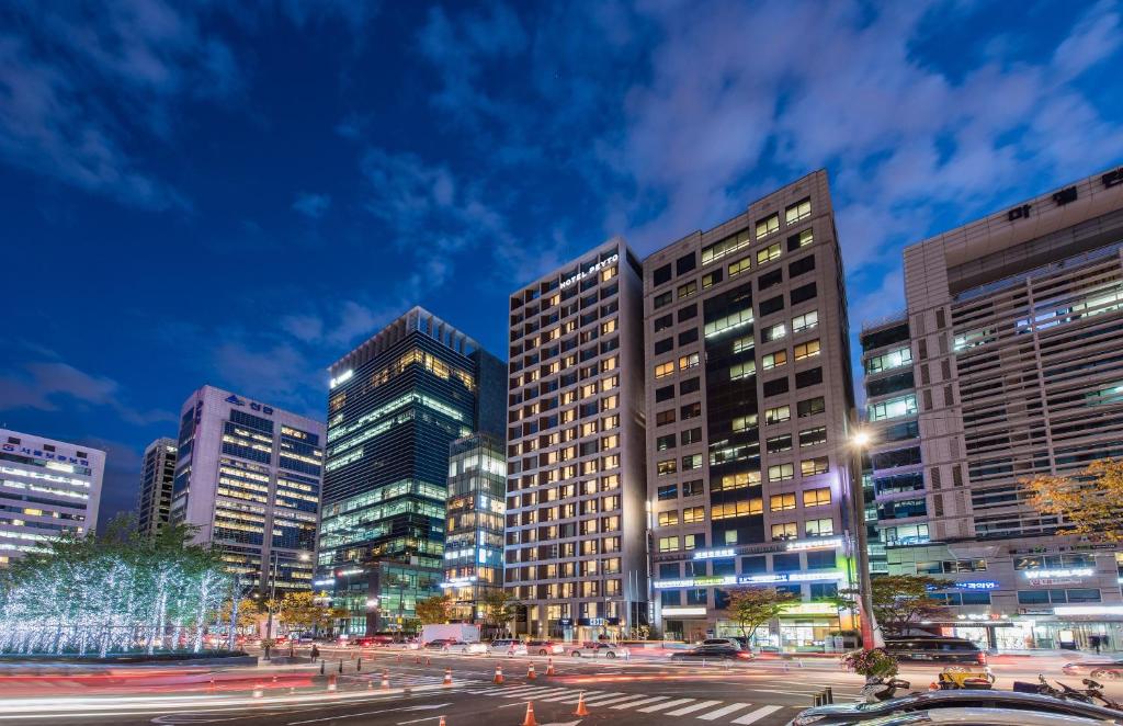 a city skyline with tall buildings at night at Hotel Peyto Samseong in Seoul