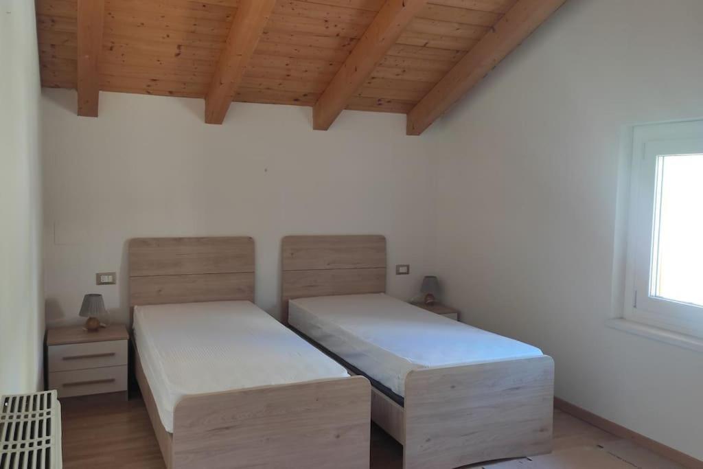 a bedroom with two beds and a window at Appartamento vacanza Coredo Trentino in Coredo