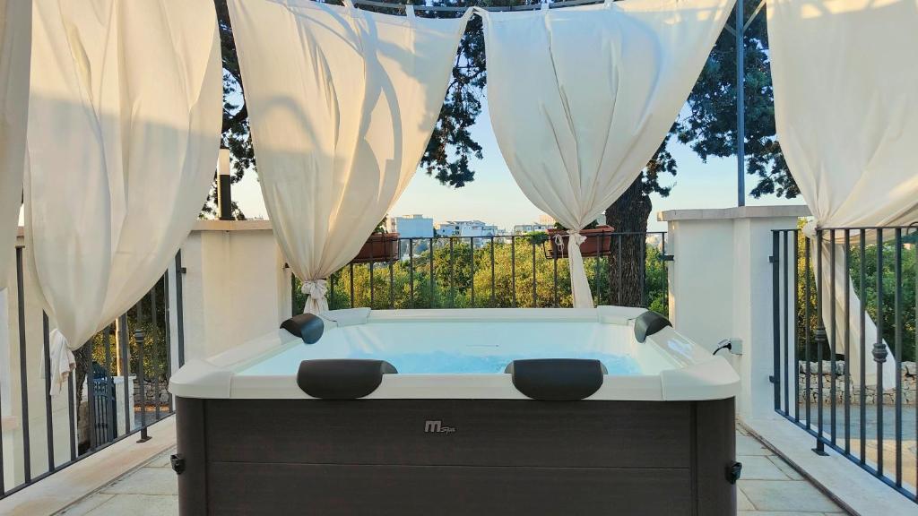 jacuzzi na balkonie z zasłonami w obiekcie Dimora Belvedere w Alberobello