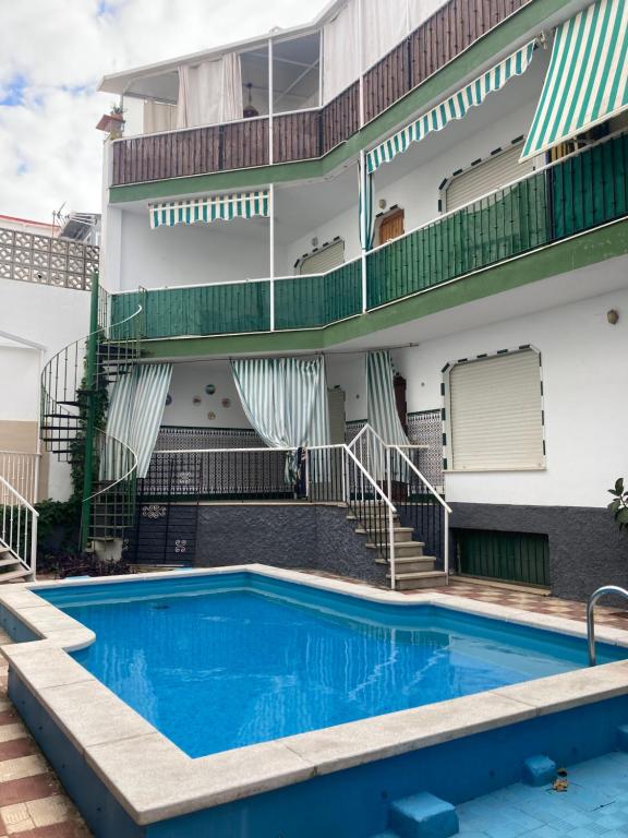 una piscina frente a un edificio con escaleras en Punta house, en Punta Umbría