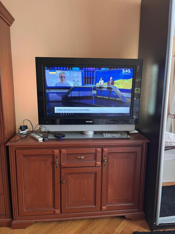 a flat screen tv sitting on top of a wooden cabinet at Затишна Квартира в центрі міста in Luts'k