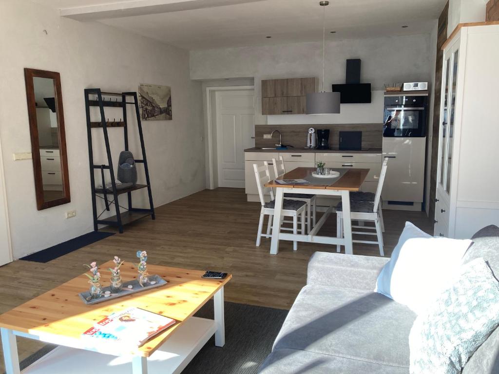 un salon avec une table et une cuisine dans l'établissement Ferienwohnungen Garzke, à Neustadt