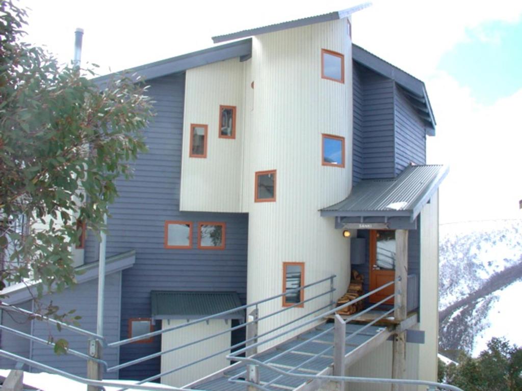 a building with a staircase leading up to the door at Sanki in Mount Hotham