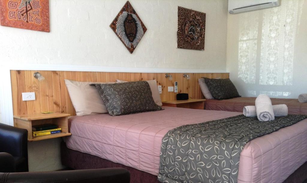 a hotel room with two beds and a couch at Winchester Motel in Moree