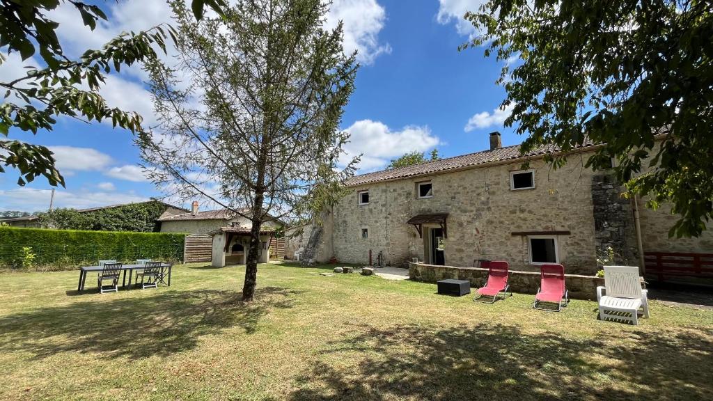 un groupe de chaises assises devant un bâtiment dans l'établissement Gîte Le Perche Rose, à Eymet