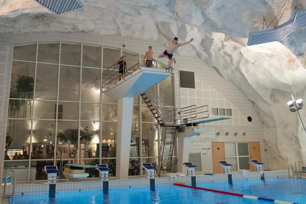a group of people jumping off of a swimming pool at 2 etasje leilighet med 2 soverom in Harstad