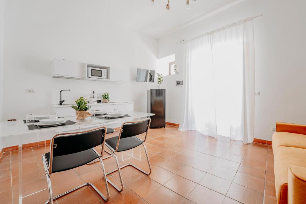 a kitchen with a table and chairs in a room at New Design Ortigia in Syracuse