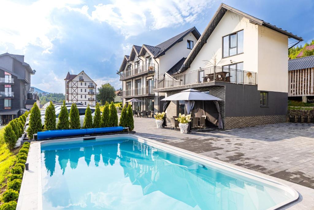 a swimming pool in front of a house at Comfort House in Bukovel