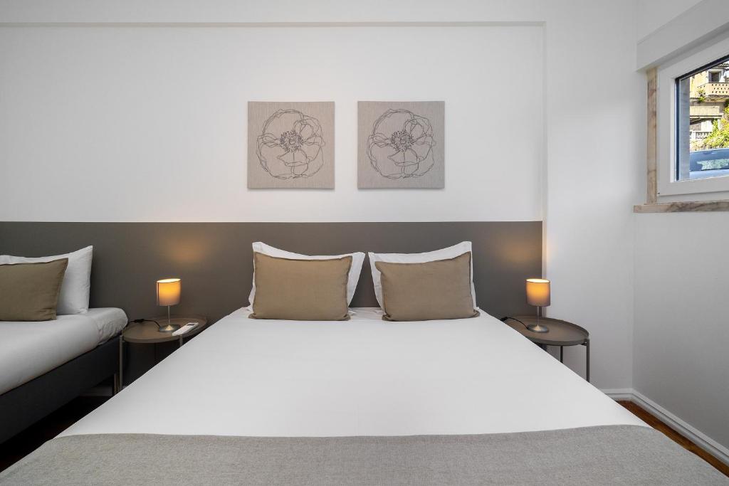 a bedroom with a large white bed and two lamps at WHome Peaceful Algés Family Home away from City Noise in Algés