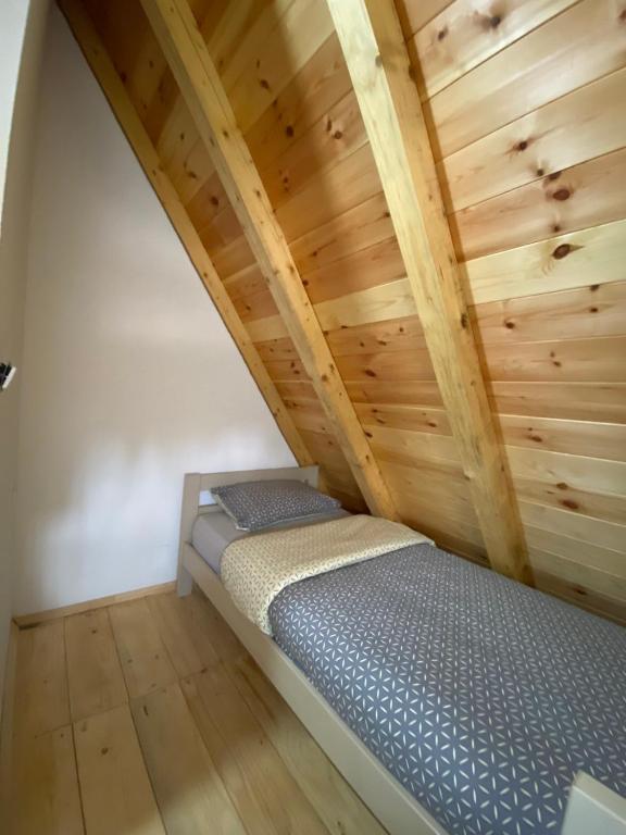 a bed in a room with wooden ceilings at Žabljak- FamilyOasis in Žabljak