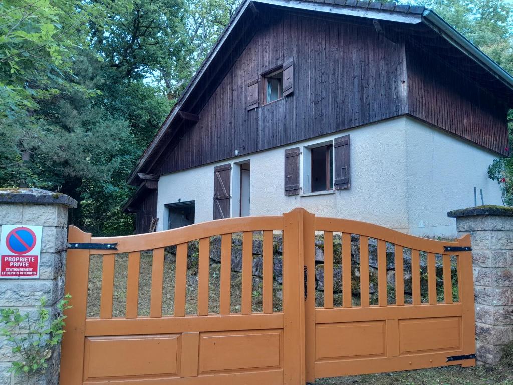 a wooden fence in front of a house at Proche de Genève et des stations de ski Ménage fait par le client-Very good prices but you have to cl-ean t-he room in Saint-André-de-Boëge