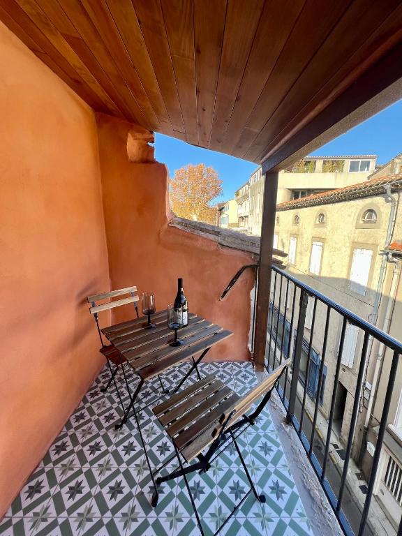 d'un balcon avec une table en bois et un banc. dans l'établissement Maison de ville avec garage au centre-ville, à Carcassonne