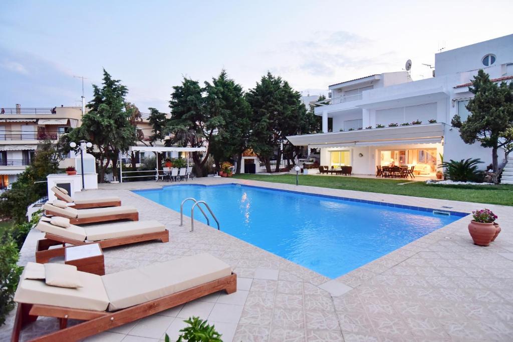 a swimming pool with lounge chairs and a house at La Maison Blanche in Kavala