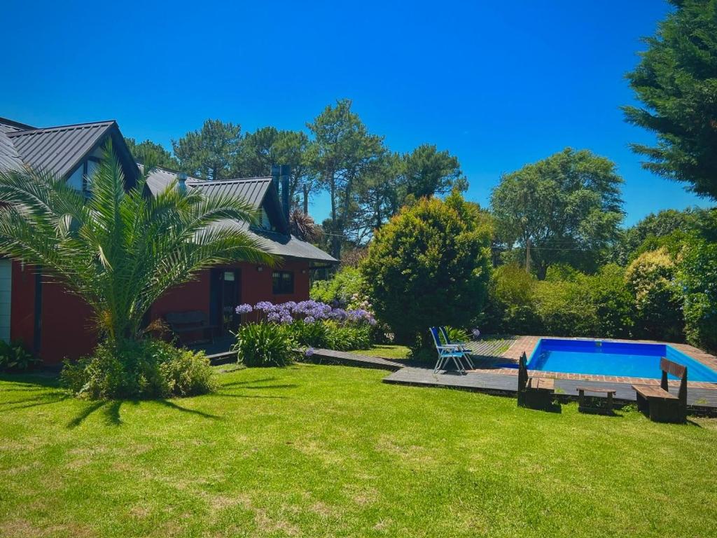 ein Haus mit einem Garten mit einem Swimmingpool in der Unterkunft Casa Tulio y Rosa in Sierra de los Padres