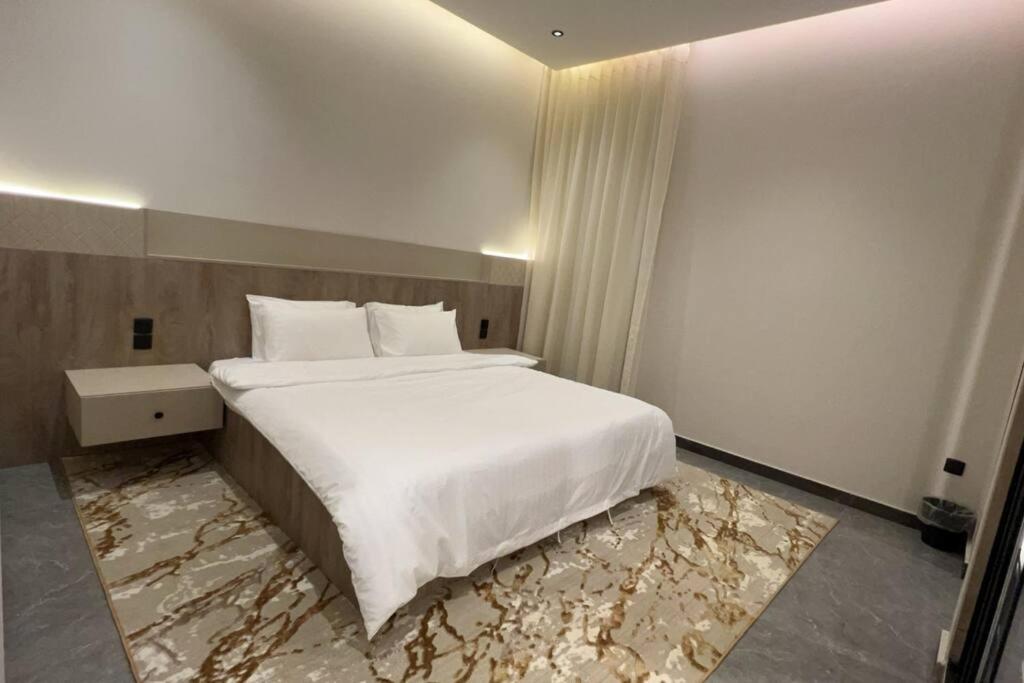 a bedroom with a large bed with a marble floor at The N&N Appt in Al Madinah