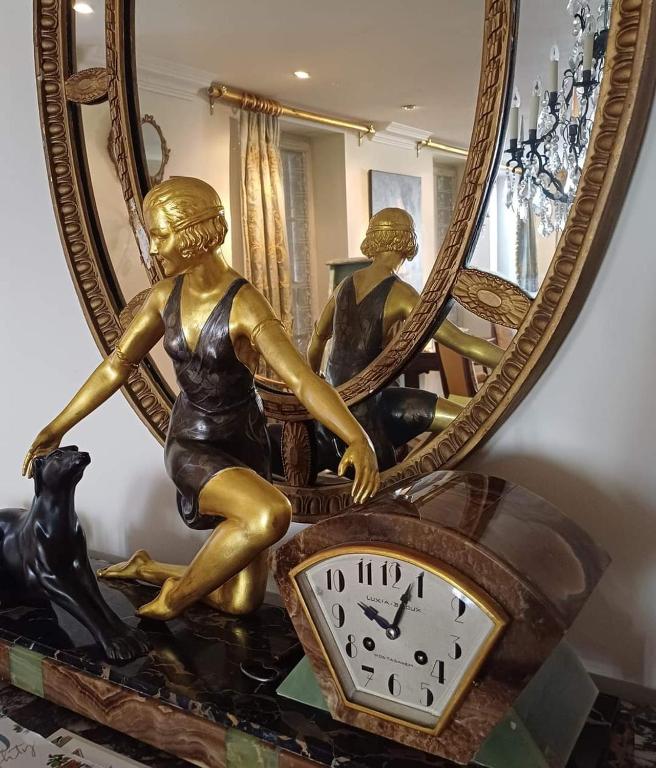 une horloge avec une femme et un chien devant un miroir dans l'établissement Place de la Bastide, à Sainte-Foy-la-Grande