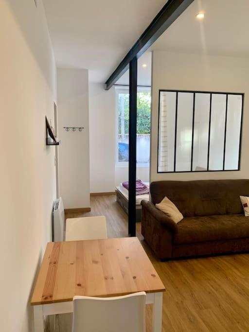 un salon avec une table et un canapé dans l'établissement Studio hyper centre parking facile, à Agen