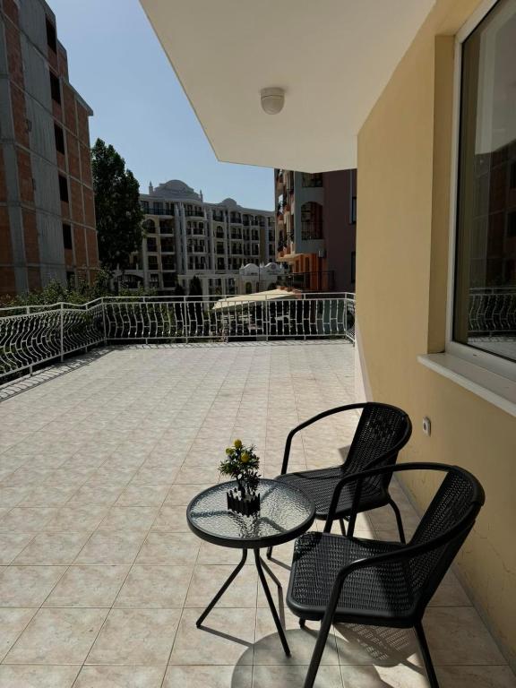 a patio with two chairs and a table on a balcony at Апартамент Александър in Sunny Beach