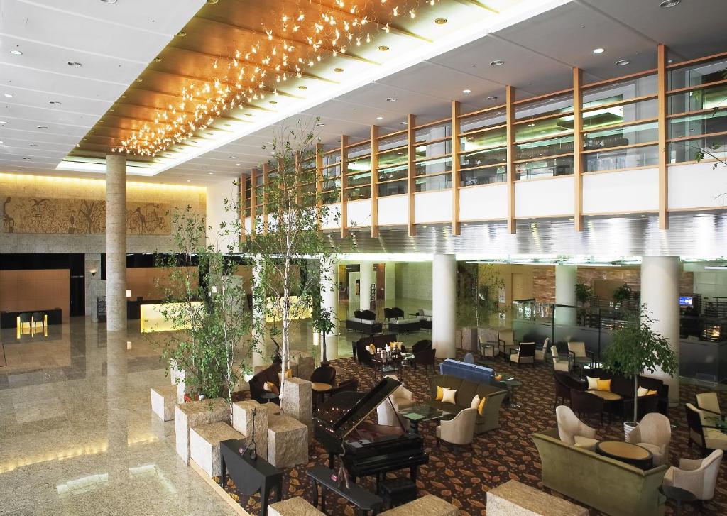 a lobby of a hotel with tables and chairs at Grand Plaza Cheongju Hotel in Cheongju
