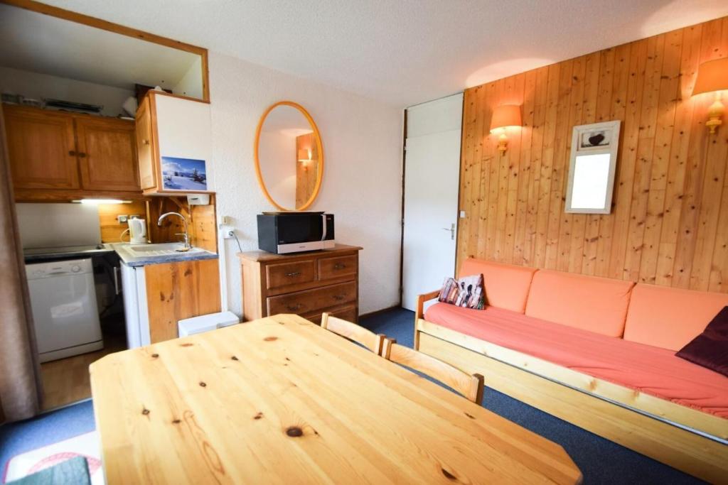 Cette chambre dispose d'un canapé, d'une table et d'une cuisine. dans l'établissement Résidence Les Hameaux I - Studio 3/4 pers - LES HAMEAUX 1 - PLAGNE VILLAGES MAE-6134, à Aime La Plagne