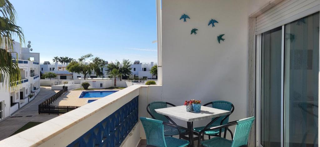 a balcony with a table and birds on the wall at Santa Luzia Apartment in Santa Luzia