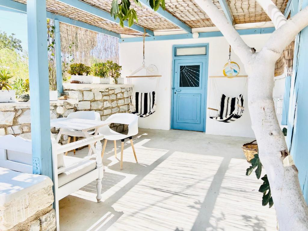 a room with a blue door and a table and chairs at Little Troll House 1 in Chrissi Akti