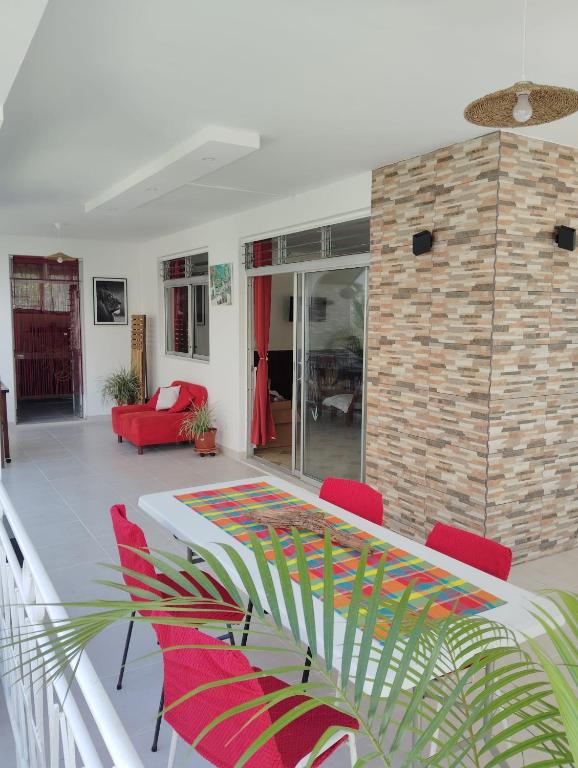 a living room with a table and red chairs at Charmant coin sur Durand in Saint-Joseph
