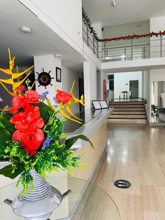 una hall con un vaso con fiori rossi di Hotel Armenia Lions ad Armenia