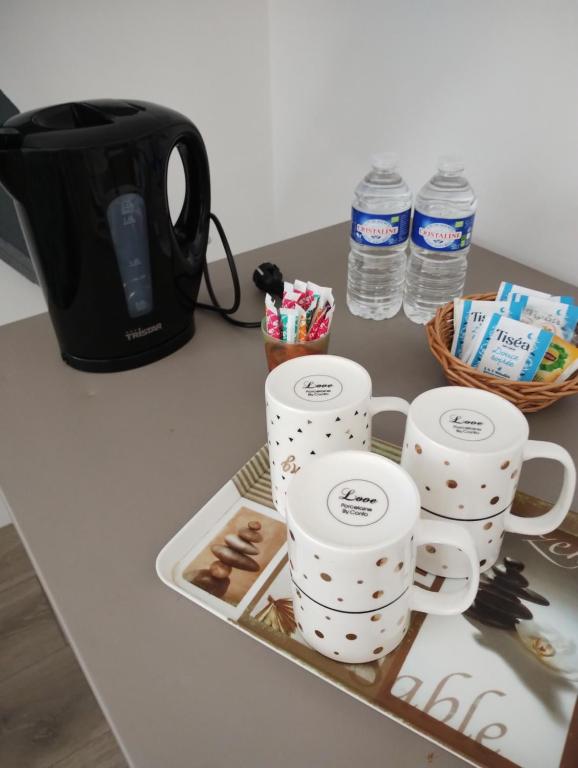- un plateau avec quatre tasses à café sur un comptoir dans l'établissement Chambres chez l'habitant proche sortie A10, à Pons
