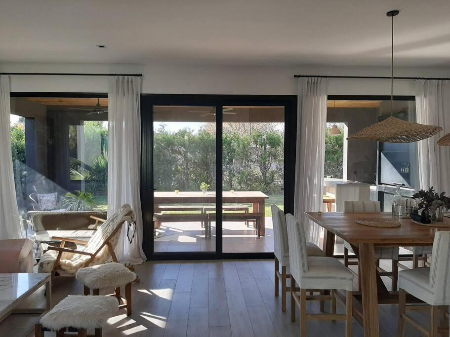 a living room with a table and a dining room at Casa en El lucero, Pilar in Manuel Alberti