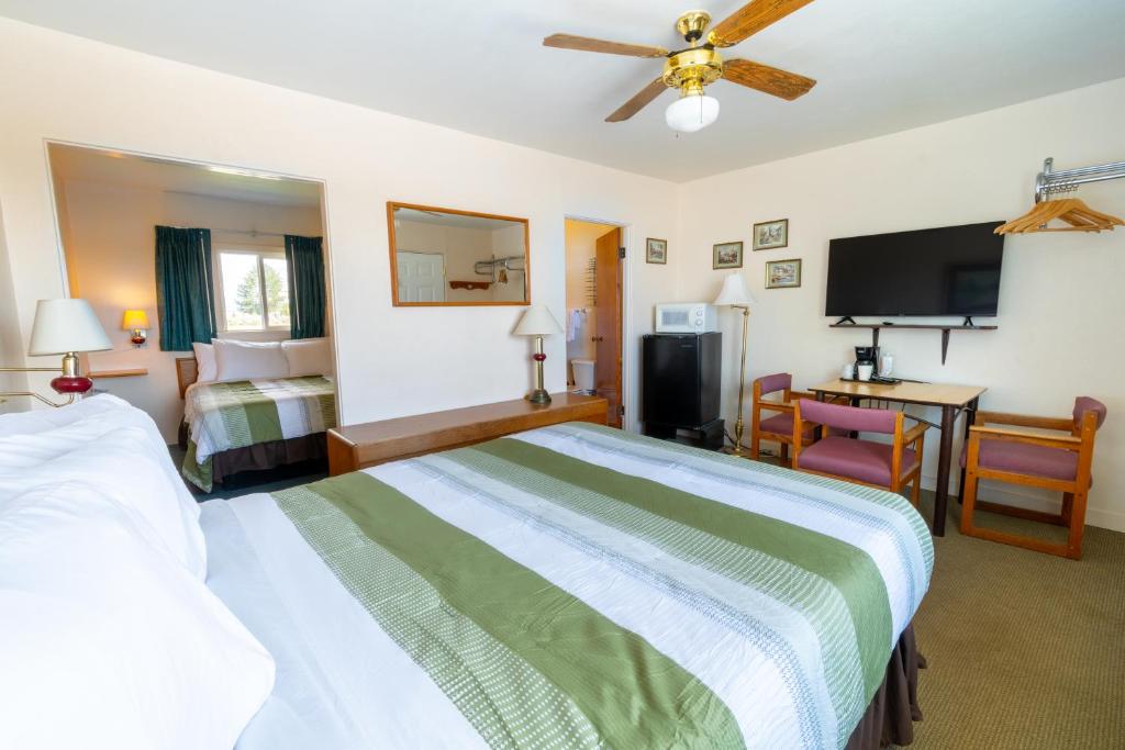 Un dormitorio con una cama grande y un televisor de pantalla plana. en Ala Cozy Motel, en Coulee City