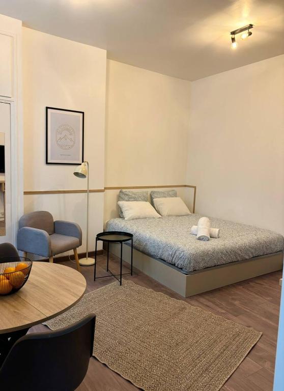 une chambre avec un lit, une table et une chaise dans l'établissement Cozy Studio, à Paris