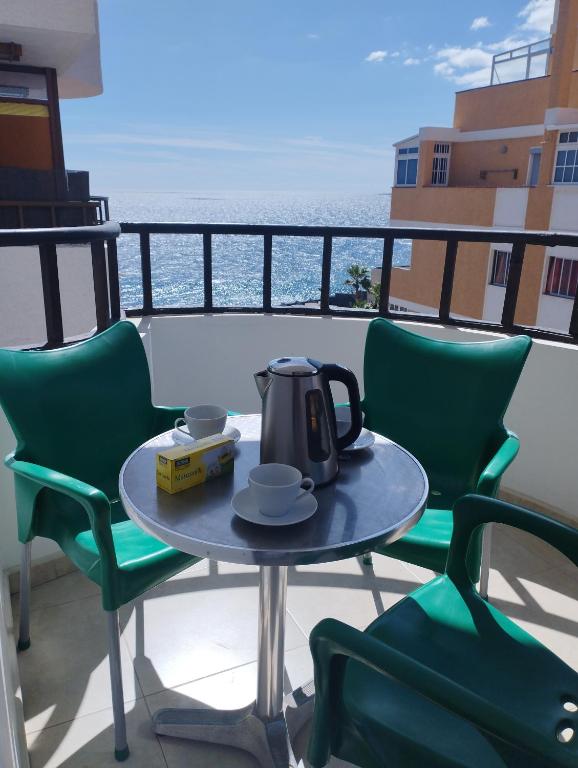 a tea kettle on a table on a balcony with chairs at Casa Yuni in Candelaria
