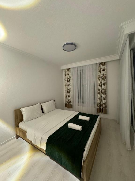 a bedroom with a bed with two towels on it at Art Apartment 2 in Prishtinë