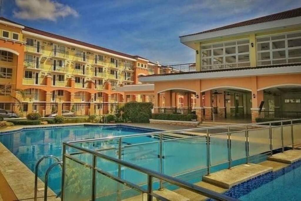 a large swimming pool in front of a building at Roms condotel at arezzo place davao in Davao City
