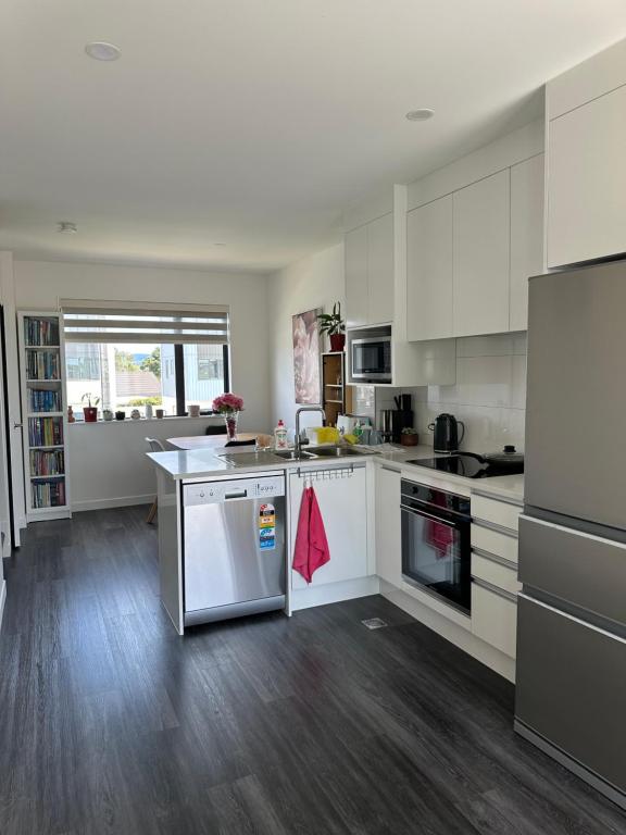 cocina grande con armarios y electrodomésticos blancos en George townhouse, en Auckland
