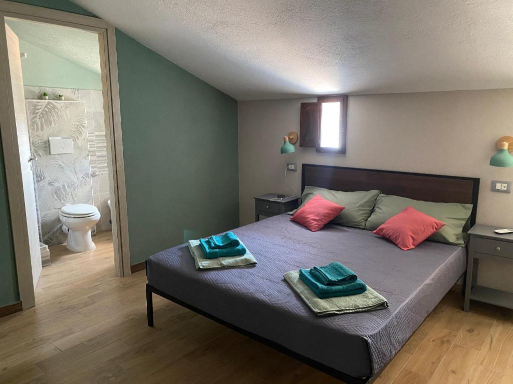 una camera da letto con un letto con due asciugamani sopra di La terrazza nel borgo a Tortora