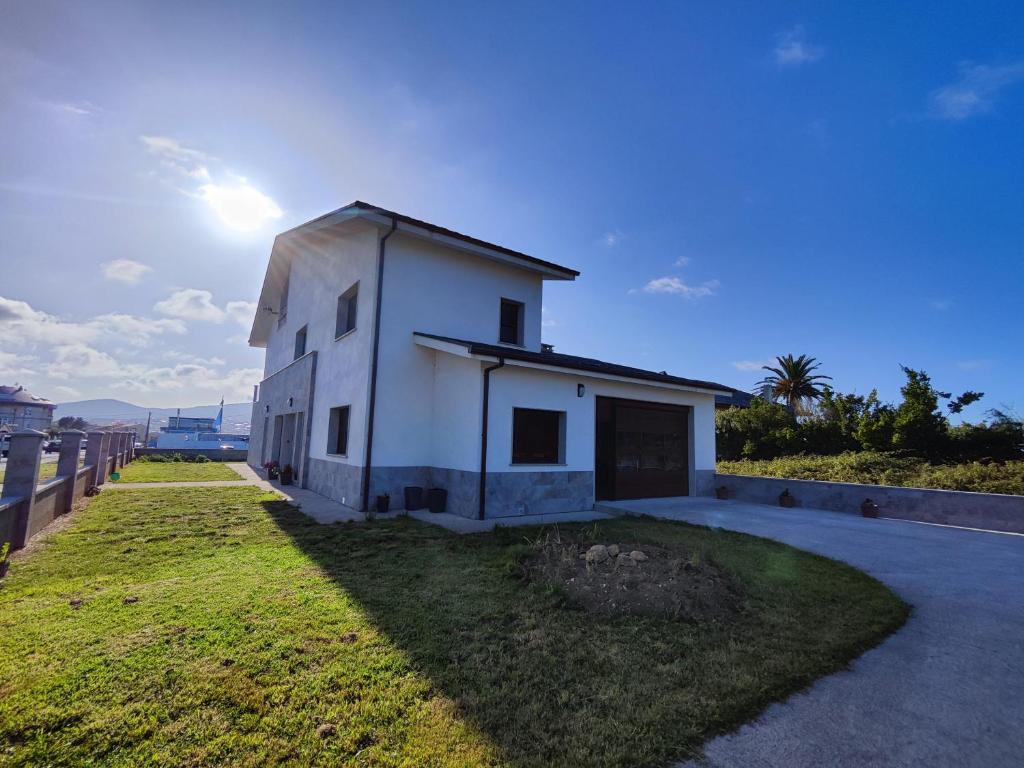 un pequeño edificio blanco con el sol en el cielo en Villa Quelle, en Sieiro