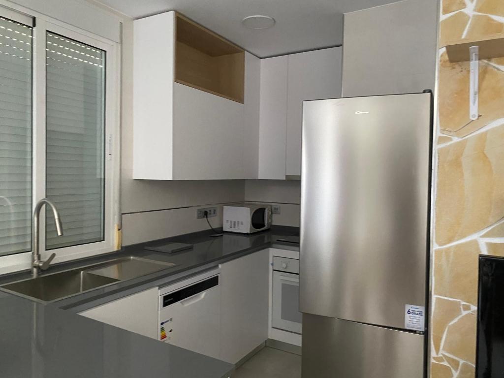 a stainless steel refrigerator in a white kitchen at Cortijo LOS MIRADORES in Vélez Blanco