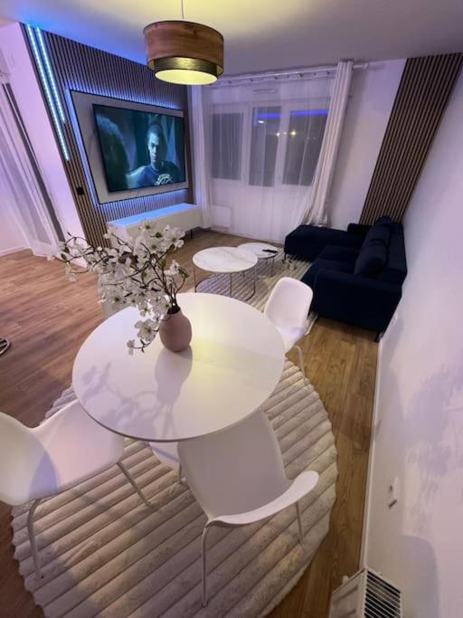 - un salon avec une table blanche et des chaises blanches dans l'établissement T4 de 87m2 à 5min de Paris, à Villejuif