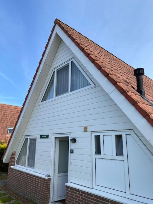 a white house with two windows and a door at Strandnah am Meer für die ganze Familie in Oostkapelle