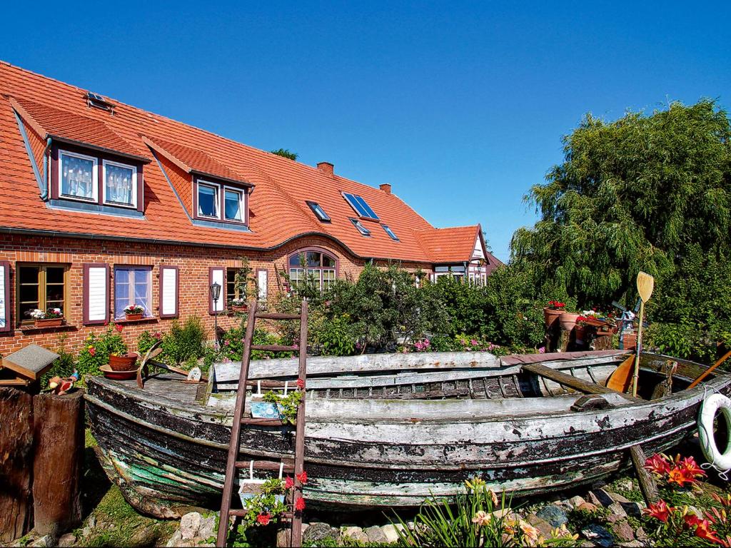 an old wooden boat in front of a house at Meine Fischerhütte in Börgerende-Rethwisch